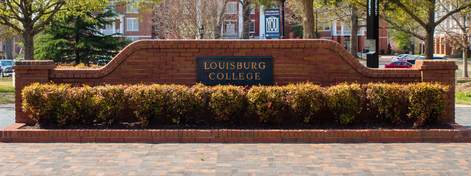 a brick wall on campus that reads Louisburg College